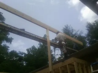 Carpenter setting a ridge beam over a new addition frame — Ice Dam Removal by Roofing Brothers in Pewaukee