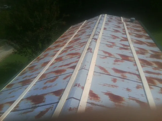 Rusted metal roof panels with new wood purlins before replacement — Storm Damage Roof Repair in Pewaukee by Roofing Brothers