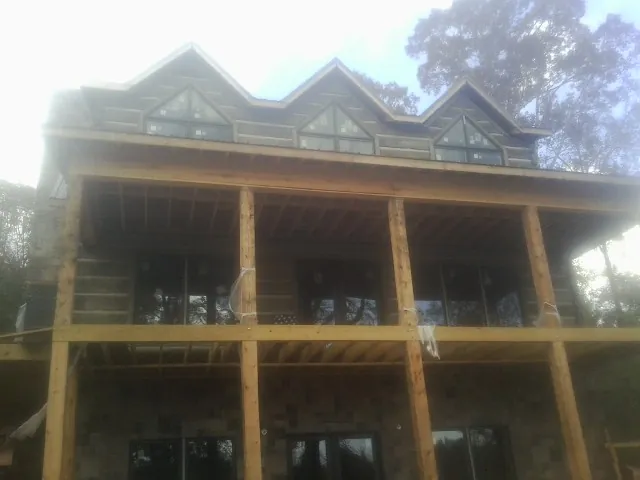 Dormers and porch framing on a large log home under construction — Roof Coating work by our crew in Pewaukee