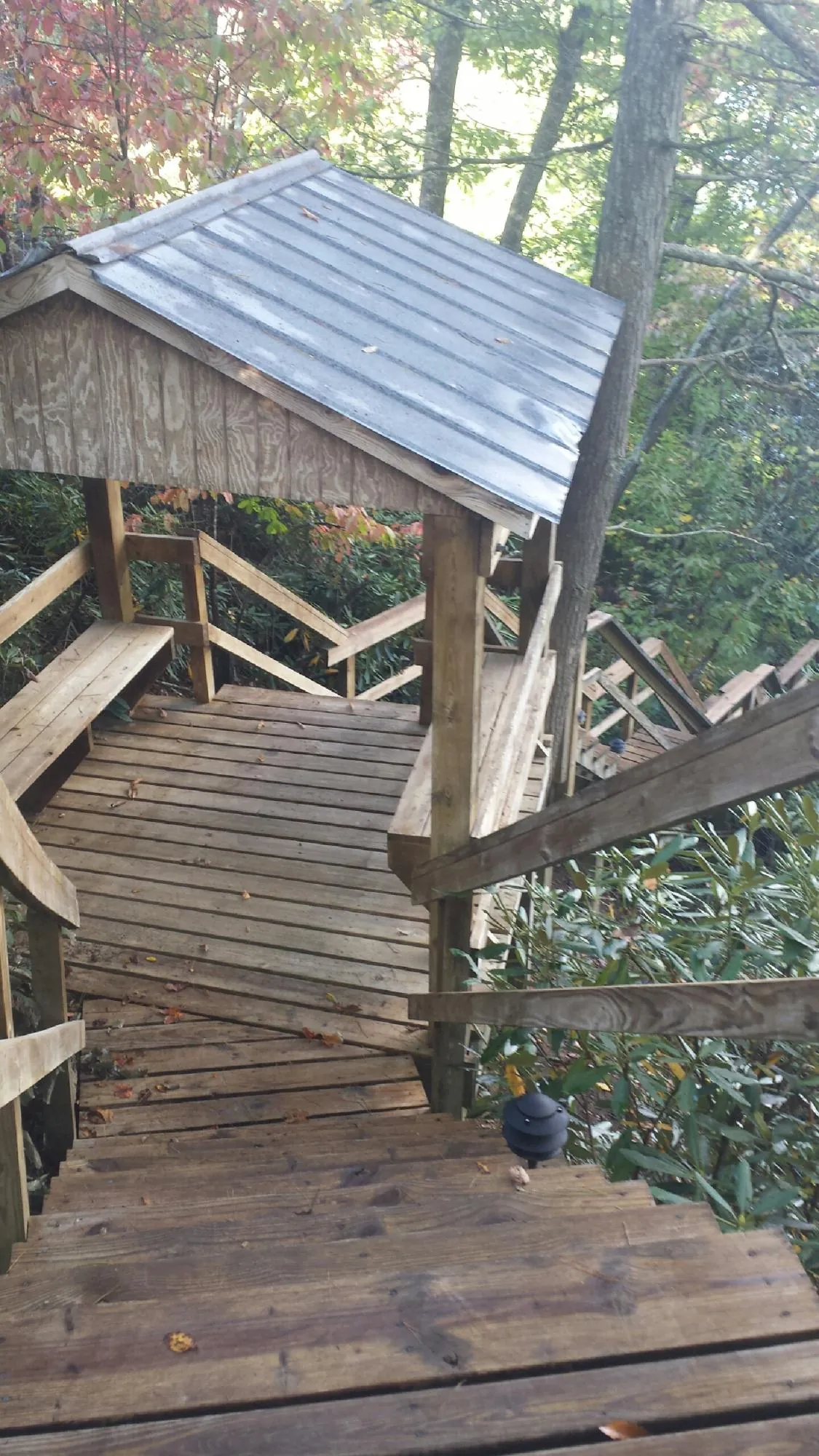 Metal roofed shelter over wooden steps on a wooded walkway — Skylight Repair & Installation work by our crew in Pewaukee